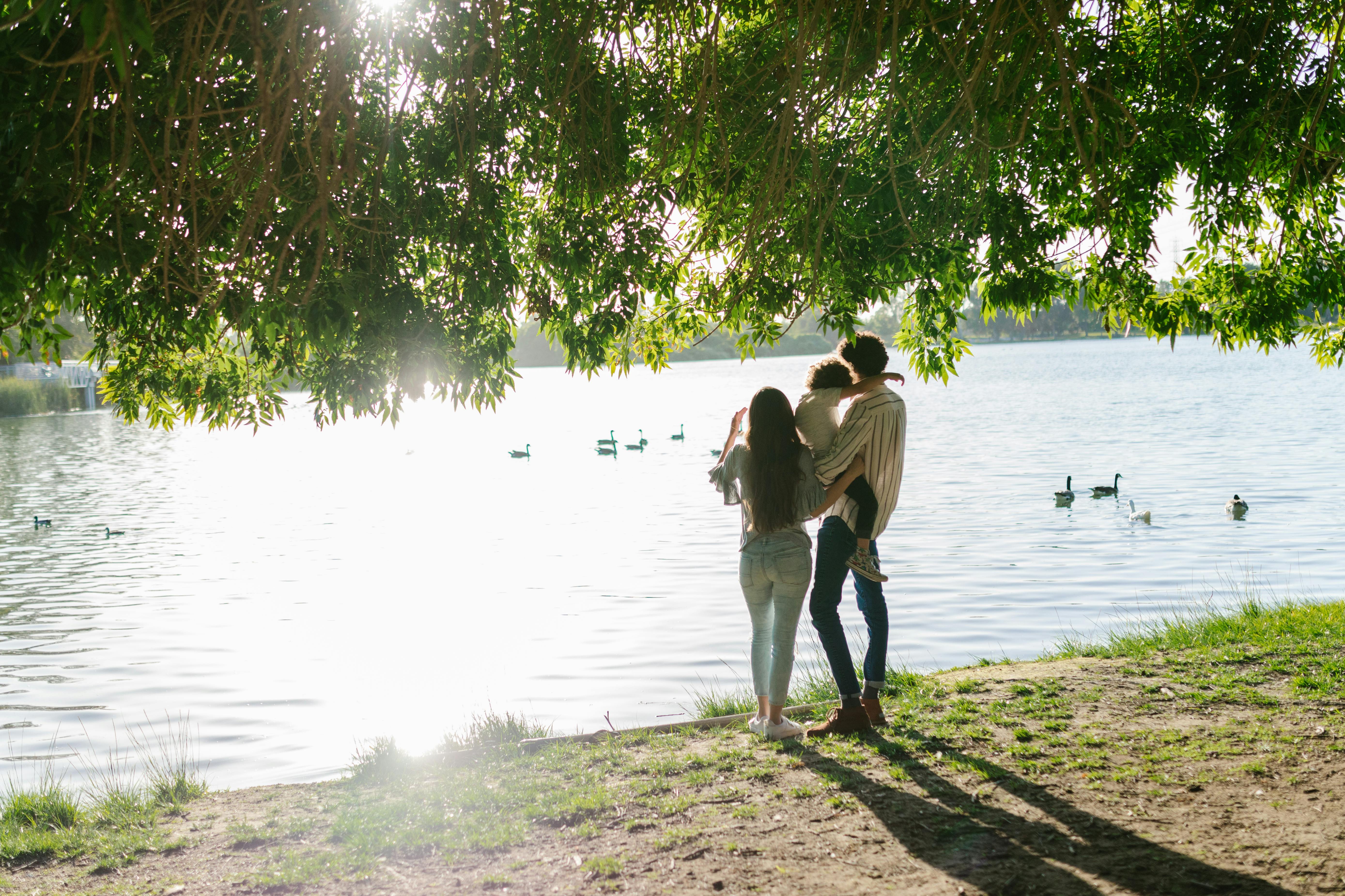 Family of mixed background sitting by a clean river